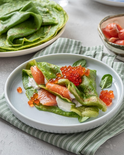 Crepes de espinacas verdes con caviar rojo de salmón ahumado y salsa de yogur