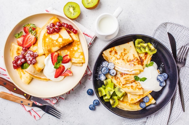 Crepes finos caseros servidos con crema cuajada, frutas.