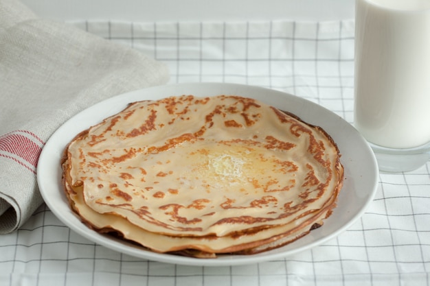 Crepes finos o panqueques con mantequilla y leche.