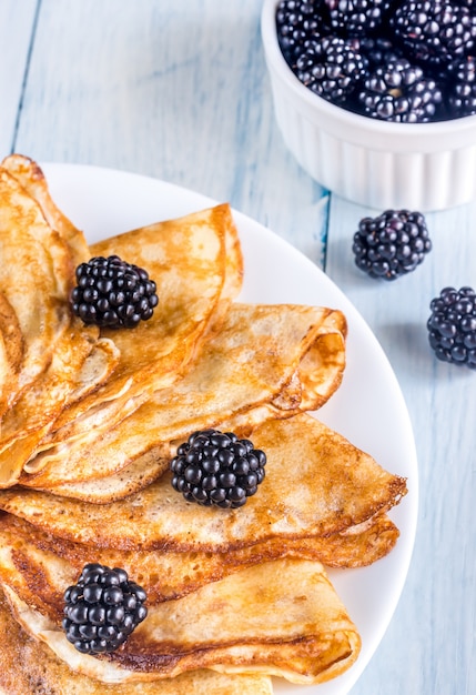 Crepes mit Brombeeren auf dem Holztisch