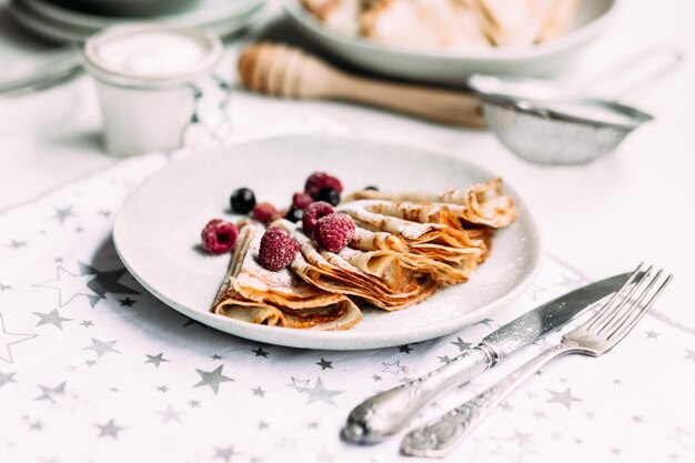 Crêpes mit hausgemachtem Hüttenkäse, Himbeeren ein grauer Teller