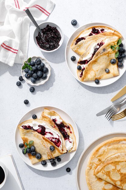 Crêpes mit Heidelbeermarmelade, Ricotta-Käse und frischen Beeren Pfannkuchen zum Frühstück Draufsicht