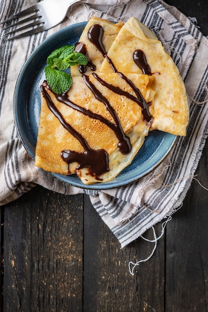 crepes panquecas finas despeje calda de chocolate prato branco bolo plano