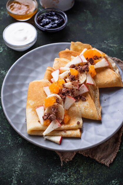 Crepes de panqueques con diferentes frutas y chocolate.