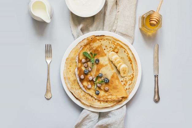 Crepes, panqueques rusos finos en un plato blanco.