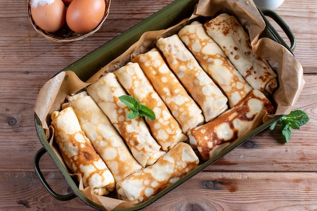 Foto crepes rellenos de requesón y pasas en mesa de madera para el desayuno