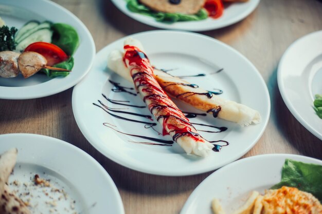 Crepes rellenos con salsa de frutas en la mesa de un café