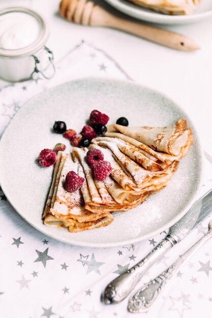 Crepes con requesón casero, frambuesas un plato gris