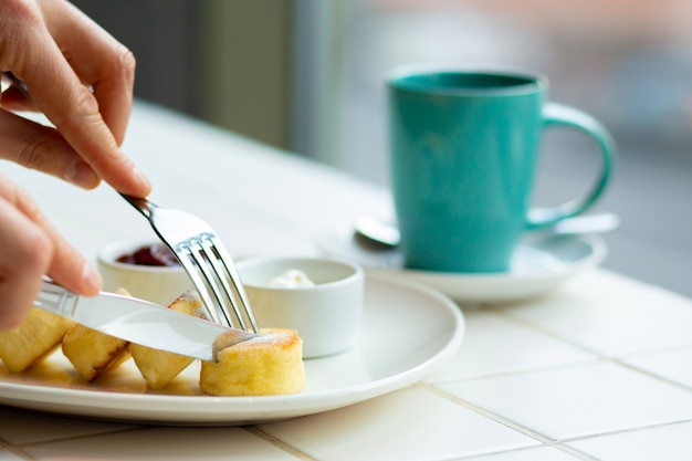 Crepes del requesón con la mermelada de frambuesa en la placa blanca, visión ascendente cercana. Saludable desayuno sabroso Pastel de queso con mermelada.