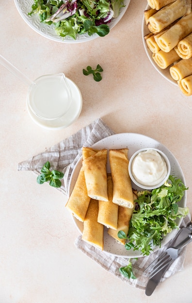 Crepes saladas o tortitas finas con pollo servidas con ensalada verde y salsa bechamel