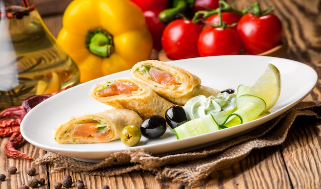 Crepes con salmón ahumado en un plato blanco