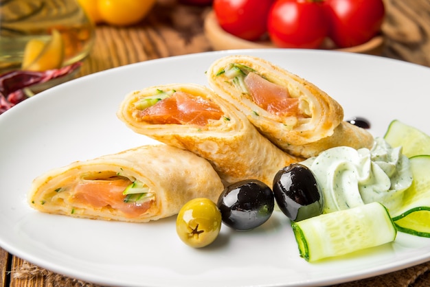 Crepes con salmón ahumado en un plato blanco