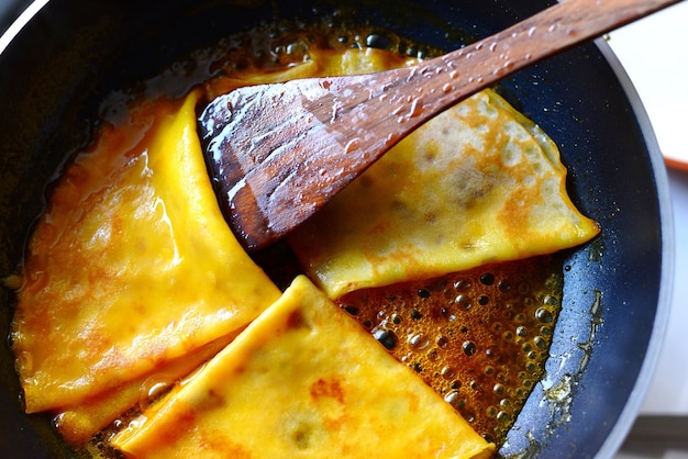 Crepes Suzette in einer Pfanne mit Holzspatel