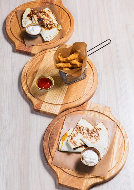 Crepes con las verduras y los naggets en la tabla de madera en un restaurante. Comida sabrosa