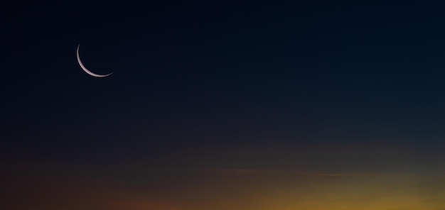 Crepúsculo del cielo del atardecer en la noche después de la puesta del sol y símbolo de la luna creciente de la religión islámica