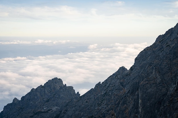 Cresta de la montaña rocosa que se eleva por encima de las nubes durante la puesta de sol eslovaquia europa