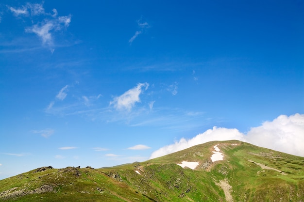 Cresta de montaña de verano y nieve en la ladera de la montaña (Ucrania, Cresta de Chornogora, Cárpatos)