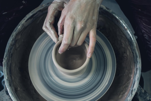 Criação de produtos cerâmicos de barro branco em close-up O escultor na oficina faz um close-up de jarro de barro