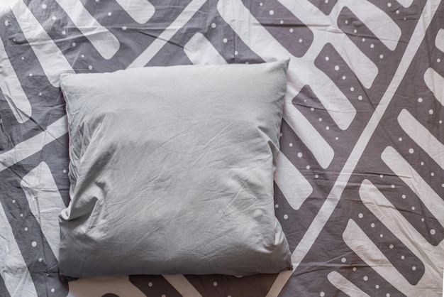 Una criada de cama con un diseño de almohada abstracto simple en la parte superior