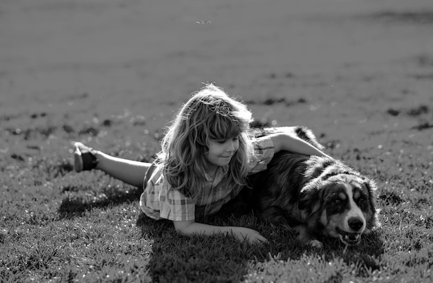 Criança abraçando um cão ao ar livre menino abraça carinhosamente seu cão de estimação criança bonita com um cachorrinho