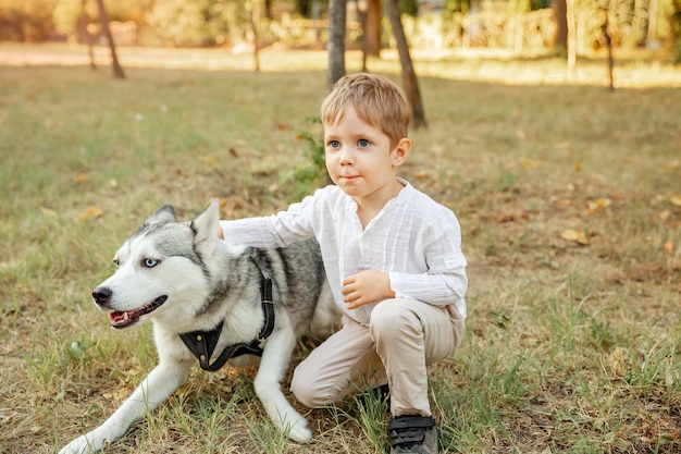 Criança acampando com cachorro de estimação. lindo menino abraçando seu cachorrinho