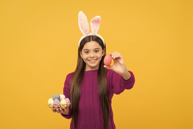 Foto criança adolescente alegre em orelhas de coelho segurando ovos de páscoa coloridos ovo de páscoa