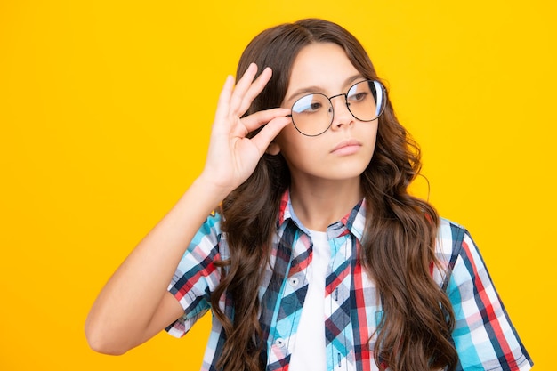 Criança adolescente com deficiência visual usa óculos olhando de soslaio Óculos infantis Garota adorável surpresa engraçada em óculos redondos tendo expressão facial chocada atônita