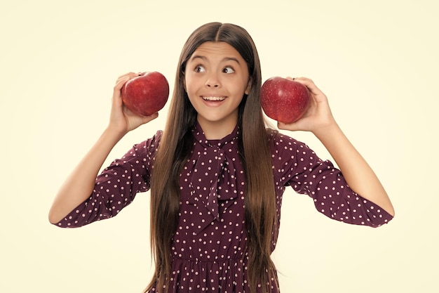 Criança adolescente com maçã em fundo amarelo isolado maçãs são boas para crianças Retrato de uma adolescente sorridente feliz