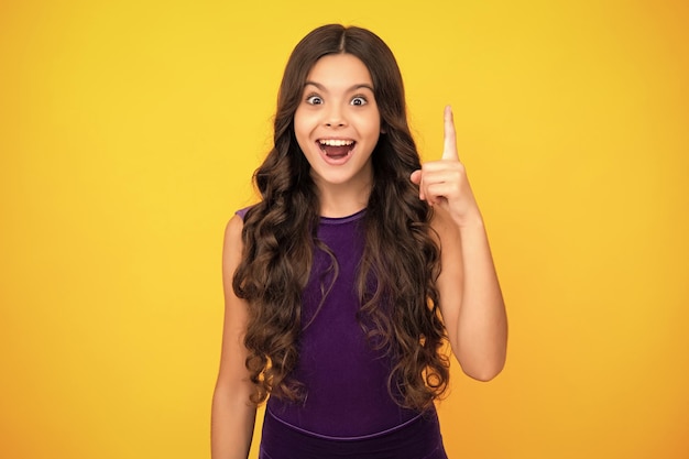 Criança adolescente confiante e bem-sucedida sobre fundo amarelo isolado mostrando e apontando para cima com o dedo número um Garoto tem uma boa ideia