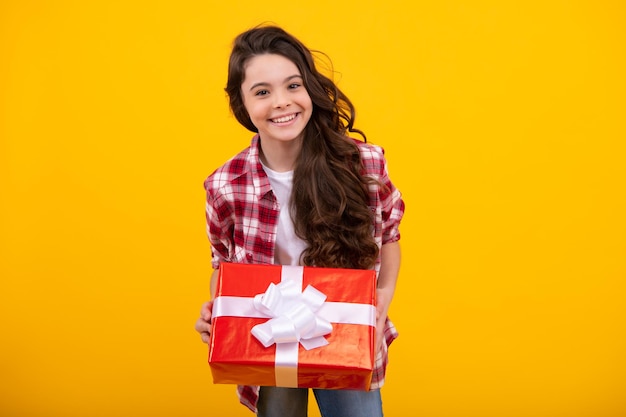 Criança adolescente emocional segura presente no aniversário Garota engraçada segurando caixas de presente comemorando feliz Ano Novo ou Natal Feliz adolescente emoções positivas e sorridentes de adolescente