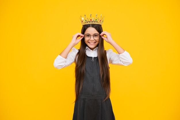 Criança adolescente na coroa da rainha isolada em fundo amarelo Menina princesa na tiara Adolescente usa diadema Garota feliz enfrenta emoções positivas e sorridentes