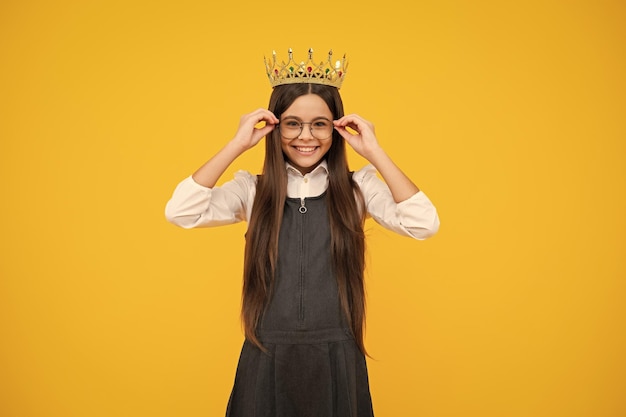 Criança adolescente na coroa da rainha isolada em fundo amarelo Menina princesa na tiara Adolescente usa diadema Garota feliz enfrenta emoções positivas e sorridentes