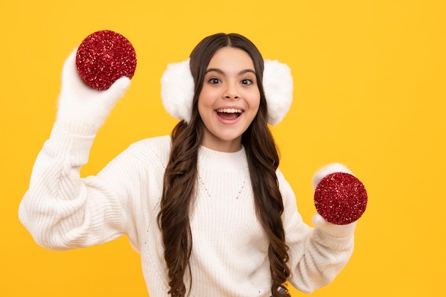 Criança adolescente santa menina na bola de natal de suéter de pele isolada em fundo amarelo feliz conceito de feriado de celebração de ano novo