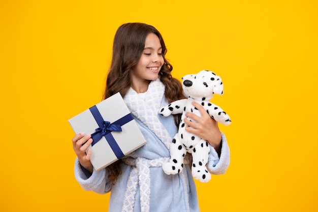 Criança adolescente segurando caixa de presente em fundo amarelo isolado Presente para aniversário de crianças caixa de presente de Natal ou Ano Novo
