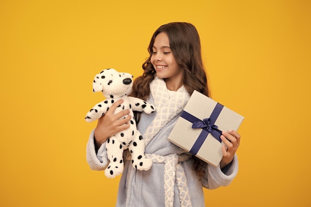 Criança adolescente segurando caixa de presente em fundo amarelo isolado Presente para aniversário de crianças caixa de presente de Natal ou Ano Novo