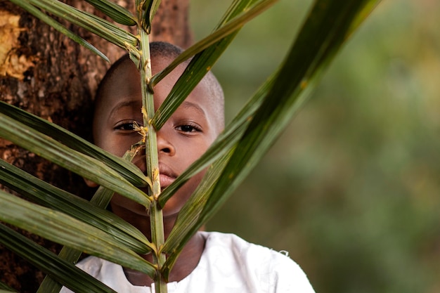 Foto criança africana segurando folhas