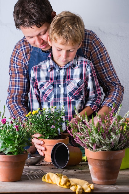 Criança ajuda o pai a plantar flores, tempo para a família em casa