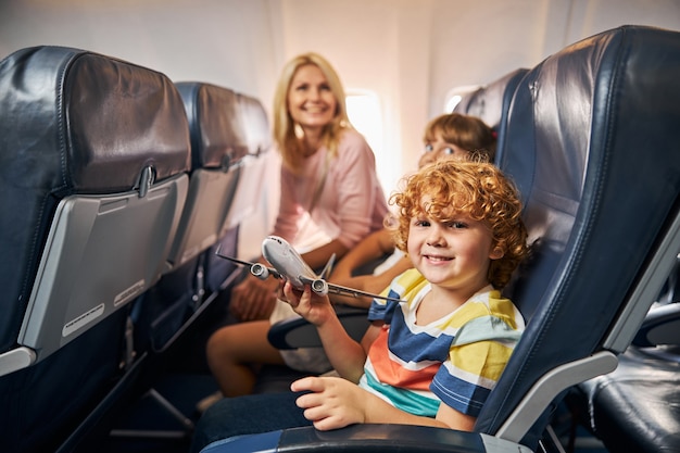 Criança alegre brincando com um avião de brinquedo