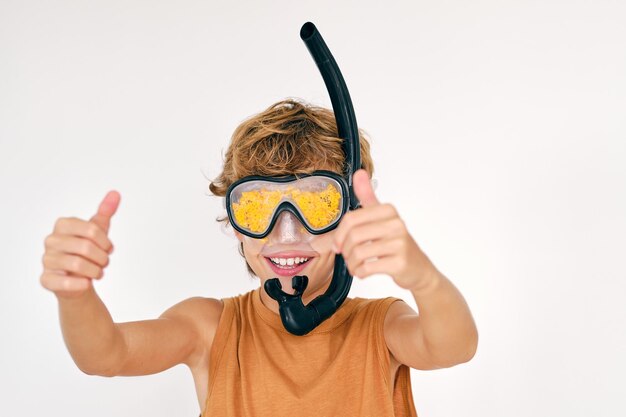 Criança alegre com óculos de mergulho com snorkel e algas demonstrando um gesto semelhante em um fundo claro