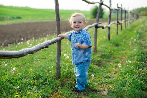 Criança alegre em pé perto da cerca