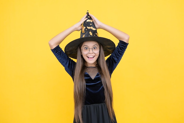 Criança alegre usa chapéu de bruxa e óculos prontos para encantamento no dia das bruxas feliz dia das bruxas