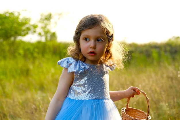 Criança anda no parque menina vestida com um vestido azul