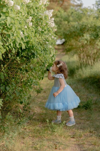 Criança anda no parque menina vestida com um vestido azul