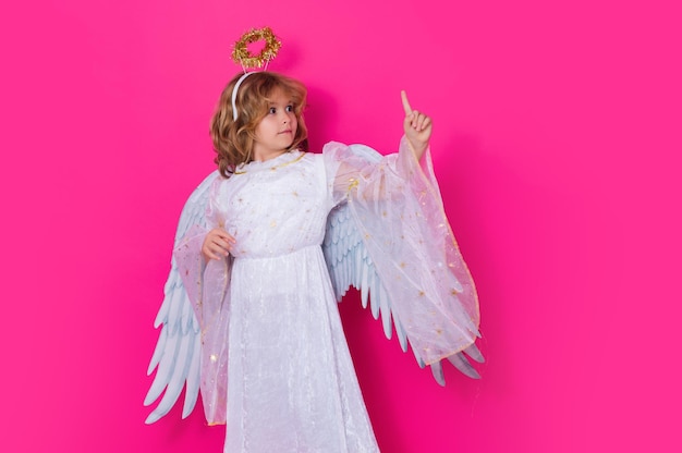 Foto criança apontando o dedo apontando o gesto criança vestindo traje de anjo vestido branco e asas de penas