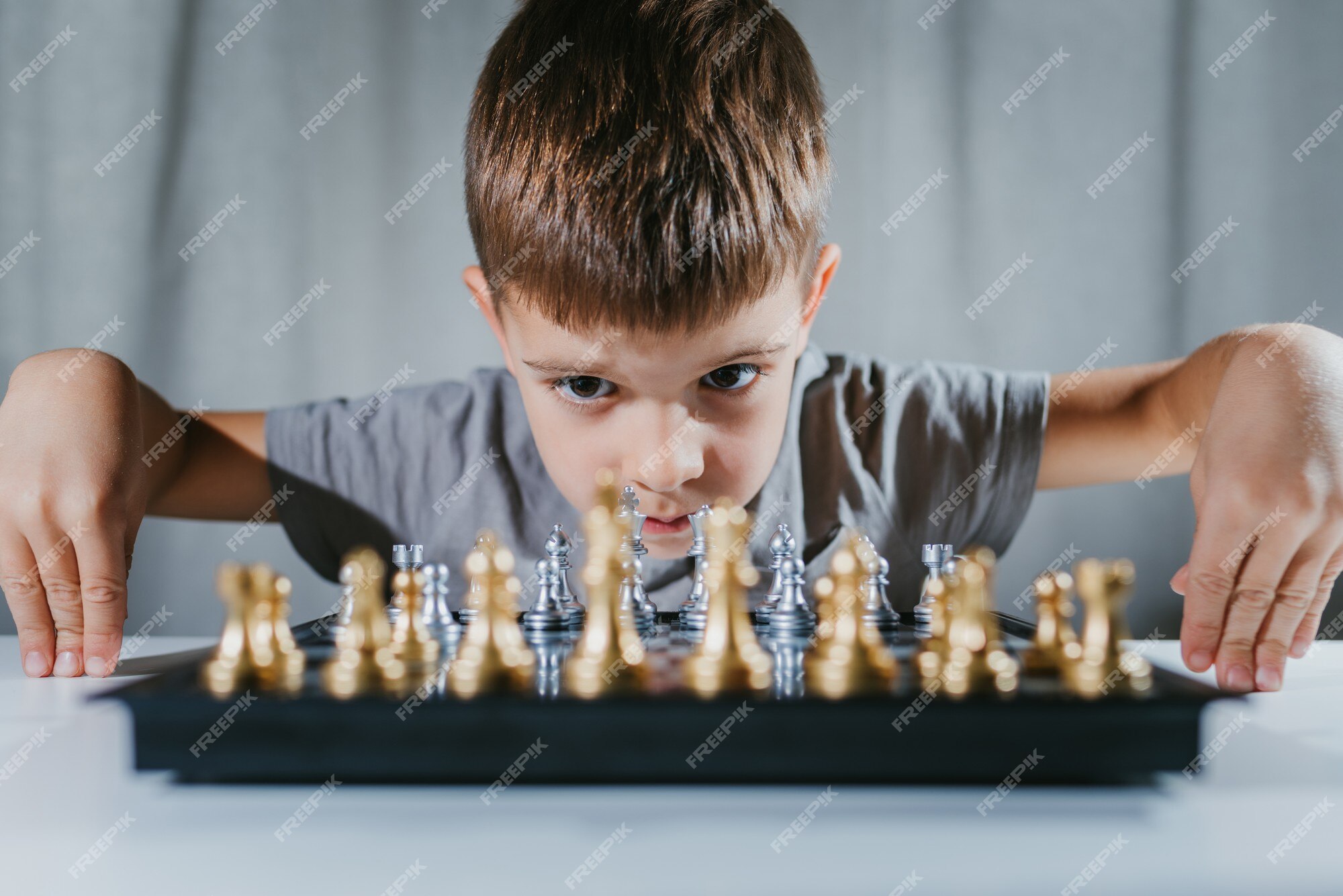 Menino Aprender A Jogar Xadrez. Criança Sentado À Mesa Em Casa Perto Do  Tabuleiro De Xadrez. Desenvolvimento Precoce. Conceito De Educação  Pré-escolar. Foto Royalty Free, Gravuras, Imagens e Banco de fotografias.  Image