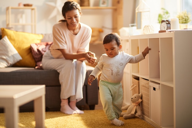 Criança aprendendo a ir com a mãe