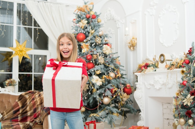 Criança aproveite o feriado. Feliz Ano Novo. Inverno. compras online de natal. Feriado familiar. Árvore e presentes de Natal. Na manhã antes do Natal. Garotinha. Momento mágico.