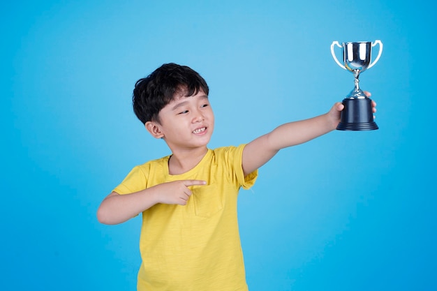 Criança asiática fofa segurando um troféu