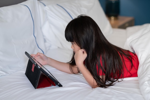 Criança assistindo tablet na cama desenho animado de criança