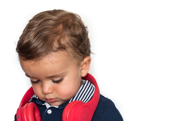 Criança assistindo vídeos no celular com fones de ouvido vermelhos e camisa azul escura